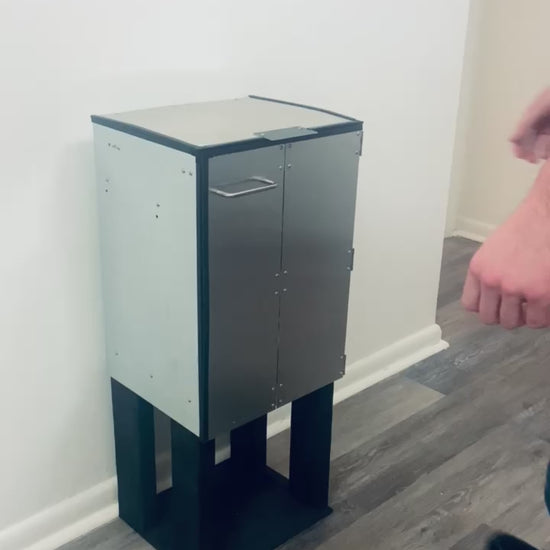 The DorrCan trash can in a kitchen being operated, the lid and doors are opened, the retainer rack is moved out of the way, the bag is cinched closed and then removed outwards horizontally from the trash can